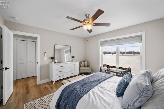 bedroom featuring ceiling fan, baseboards, and wood finished floors