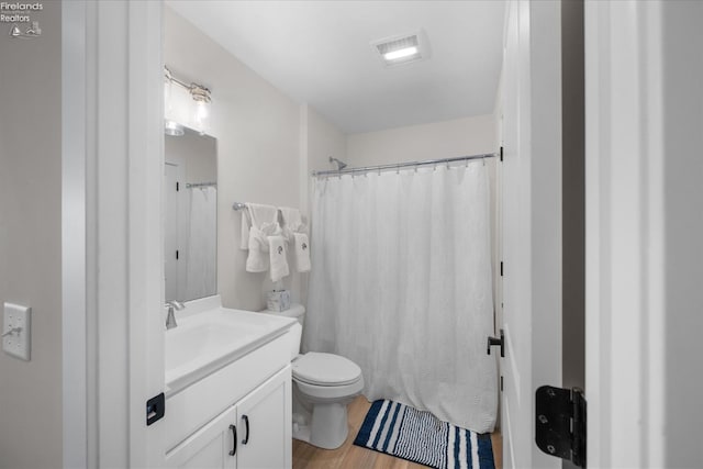 bathroom with vanity, a shower with shower curtain, toilet, and visible vents