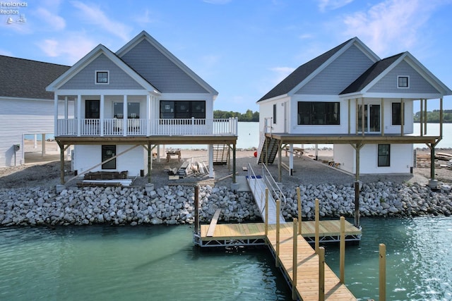 view of dock featuring a deck with water view, stairs, and a patio area