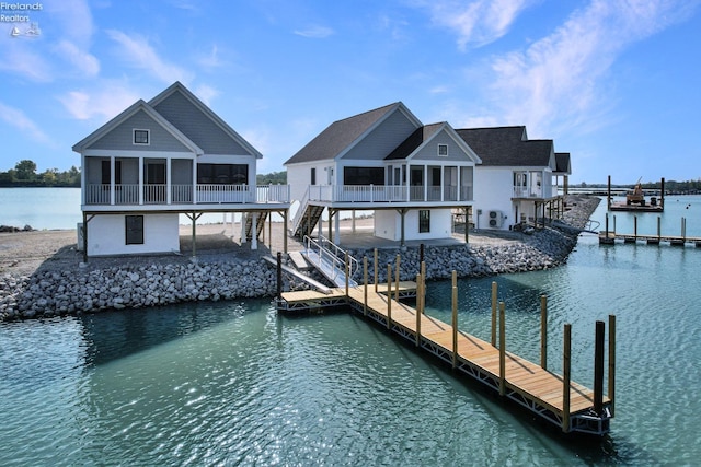 dock area featuring stairway, a water view, and a patio