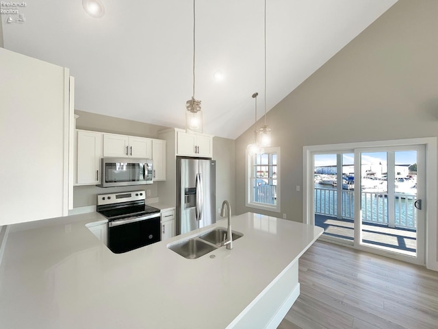 kitchen with light wood-style flooring, a sink, white cabinetry, appliances with stainless steel finishes, and light countertops