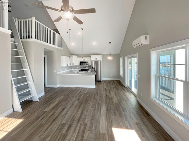 unfurnished living room featuring stairway, baseboards, dark wood finished floors, and a wall unit AC