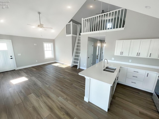 kitchen with dark wood-type flooring, ceiling fan, light countertops, white cabinets, and a sink