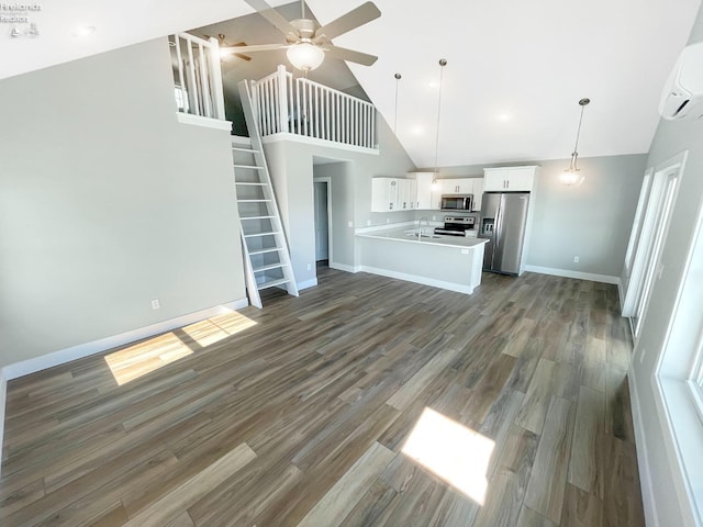 unfurnished living room with high vaulted ceiling, a sink, wood finished floors, a wall unit AC, and stairs