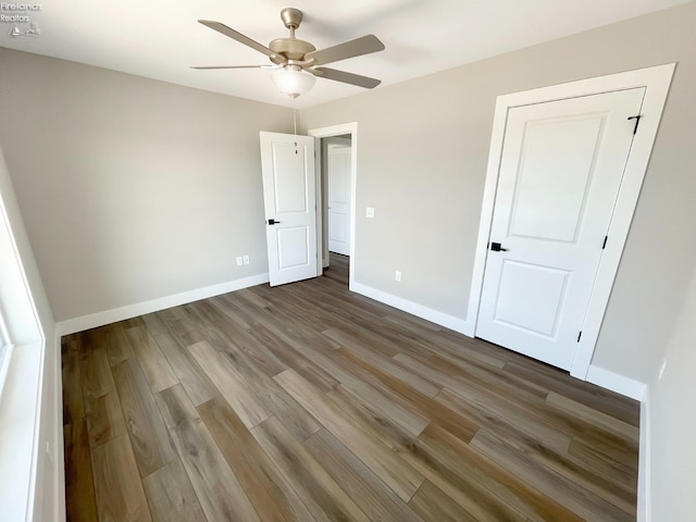 unfurnished bedroom with a ceiling fan, baseboards, and wood finished floors