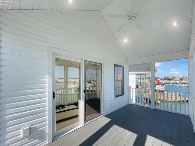 deck with a water view and ceiling fan