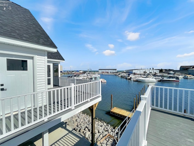 dock area with a balcony and a water view