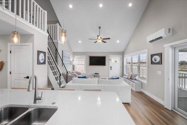 kitchen featuring a sink, high vaulted ceiling, an AC wall unit, and wood finished floors