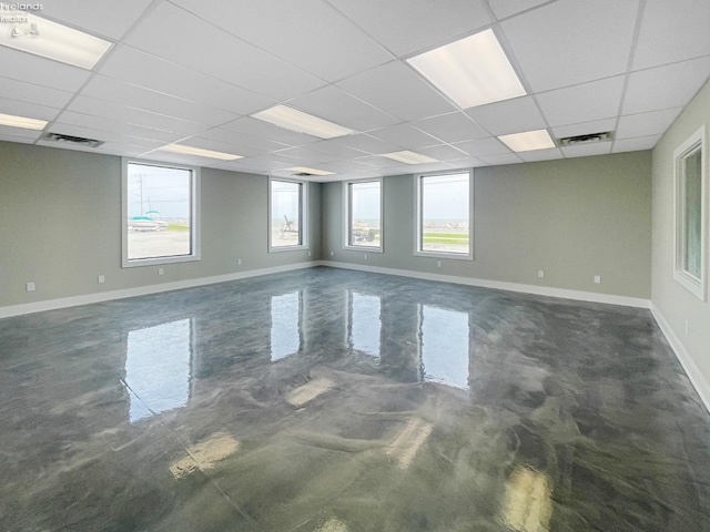 unfurnished room featuring a wealth of natural light, visible vents, a paneled ceiling, and baseboards