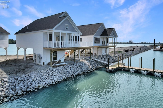 back of house featuring ac unit, a water view, and stairs