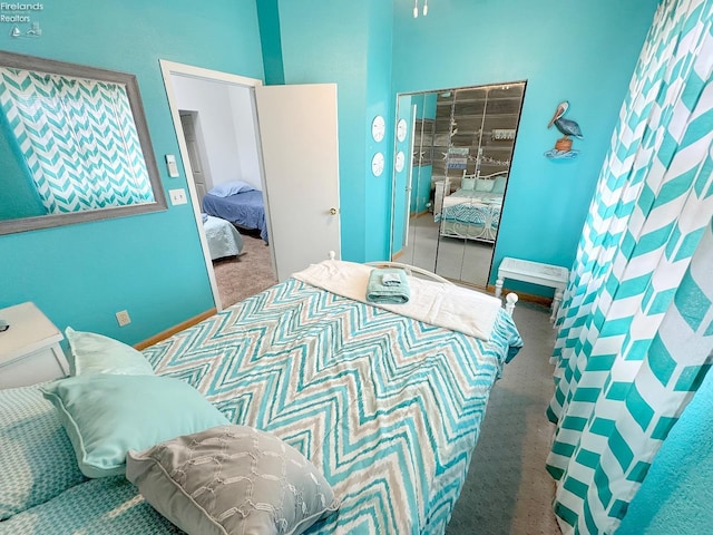 bedroom featuring a closet, baseboards, and carpet