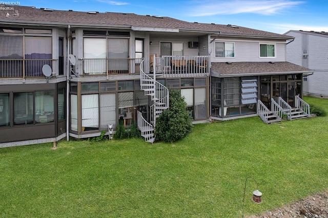 rear view of house featuring stairway, a lawn, a sunroom, and roof with shingles