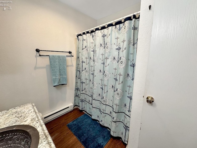 bathroom featuring a baseboard radiator, a shower with curtain, and wood finished floors