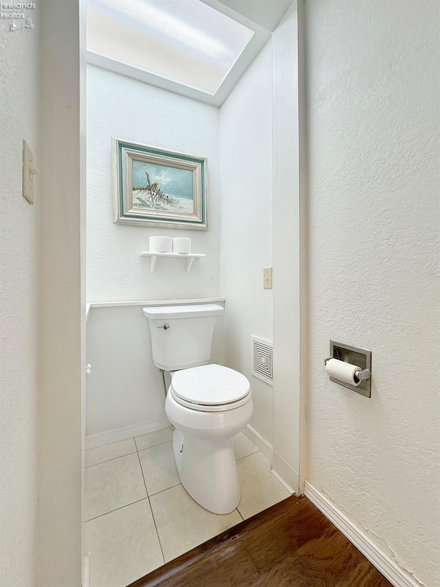 bathroom with tile patterned flooring, toilet, and baseboards