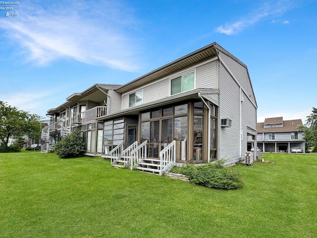 back of property featuring a yard and a sunroom