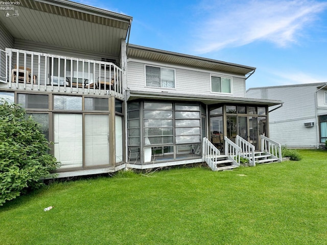 rear view of property featuring a yard and a sunroom