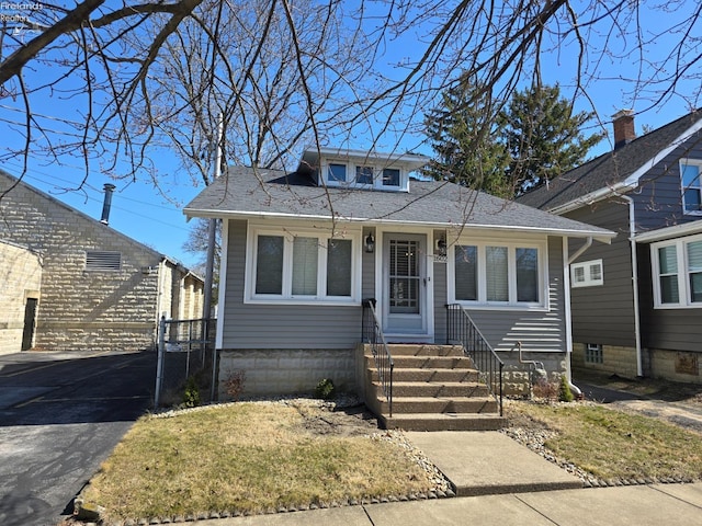 bungalow featuring entry steps and roof with shingles