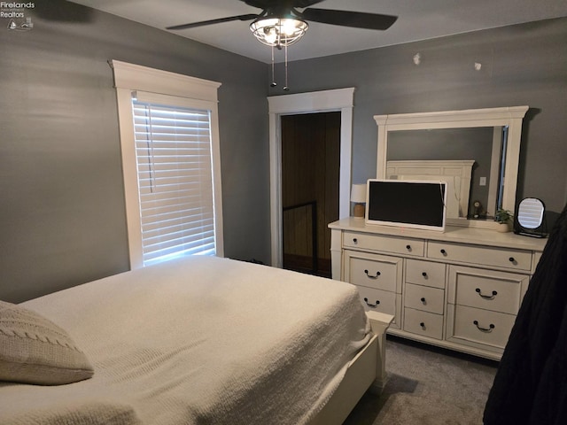 bedroom with a ceiling fan and dark colored carpet