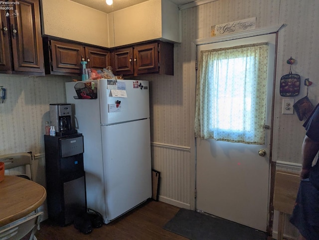 kitchen featuring dark wood-style floors, dark brown cabinets, wallpapered walls, and freestanding refrigerator