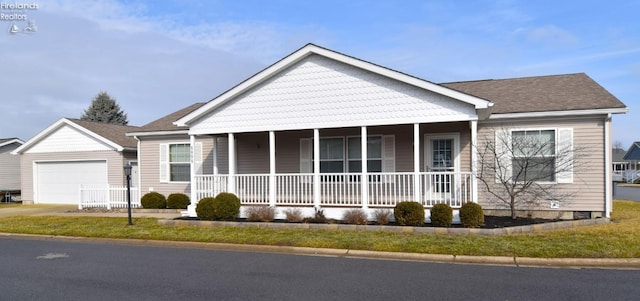 view of front of house featuring an outbuilding, an attached garage, covered porch, and driveway