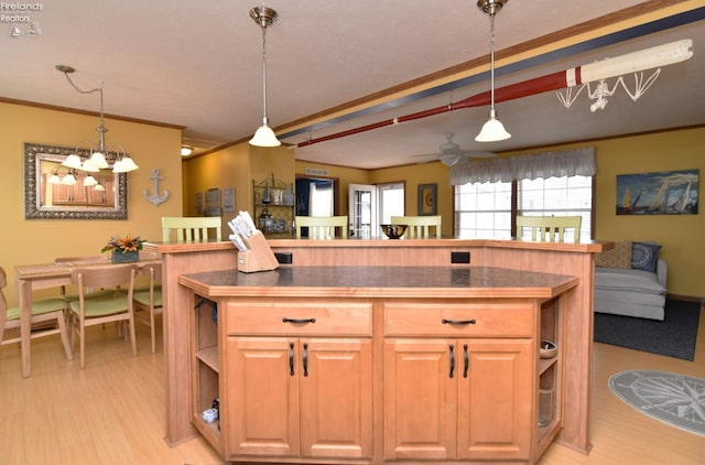 kitchen with dark countertops, light wood finished floors, crown molding, open floor plan, and open shelves