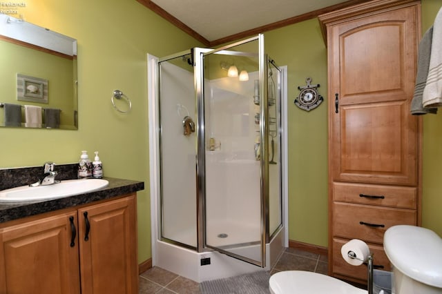 full bathroom featuring tile patterned flooring, a shower stall, toilet, ornamental molding, and vanity