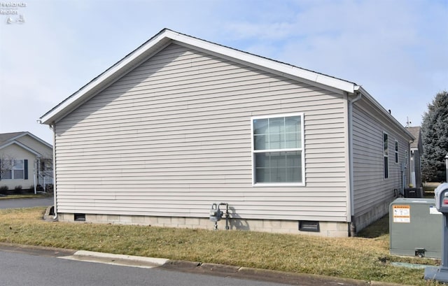 view of side of property with crawl space and a yard