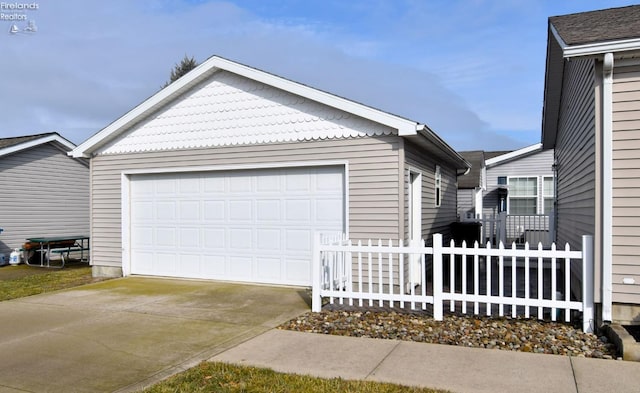 view of home's exterior featuring a detached garage, an outdoor structure, and fence