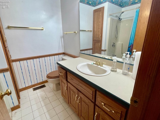 bathroom featuring tile patterned floors, visible vents, a wainscoted wall, toilet, and curtained shower