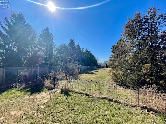 view of yard featuring a rural view and fence