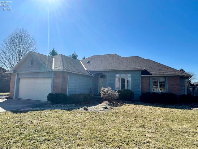 ranch-style home featuring driveway, brick siding, an attached garage, and a front lawn