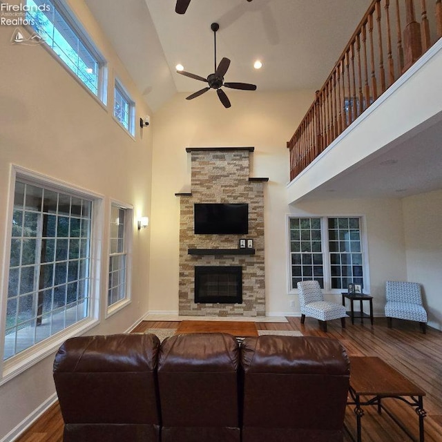 115 Beech St, Kelleys Island, OH 43438 - living area featuring wood finished floors, a fireplace, baseboards, ceiling fan, and high vaulted ceiling