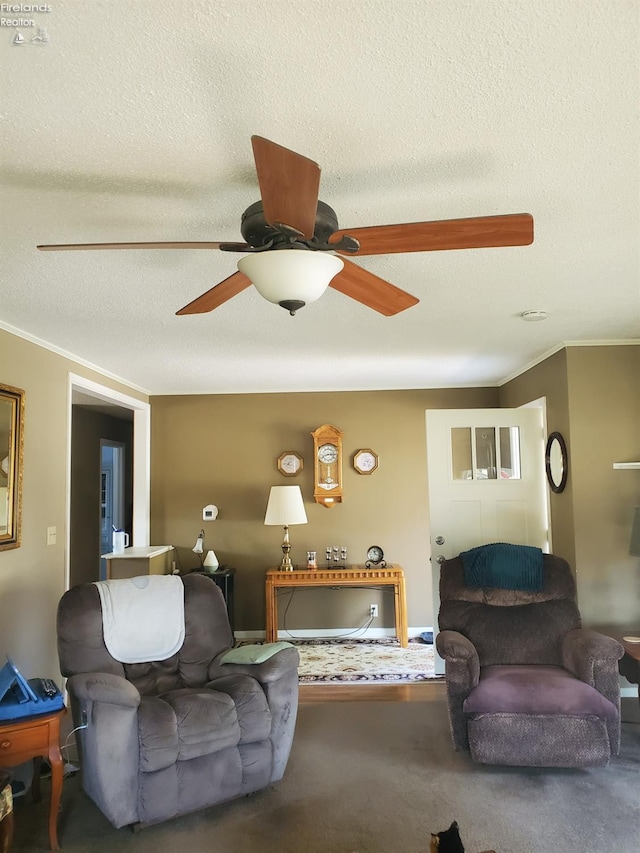 living room with ceiling fan, crown molding, carpet, and a textured ceiling