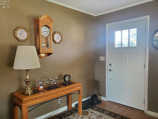 entrance foyer with crown molding, wood finished floors, and baseboards