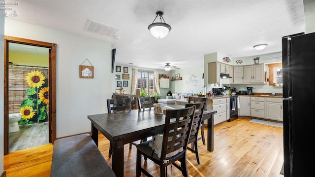 dining space featuring visible vents, ceiling fan, baseboards, and light wood-style floors