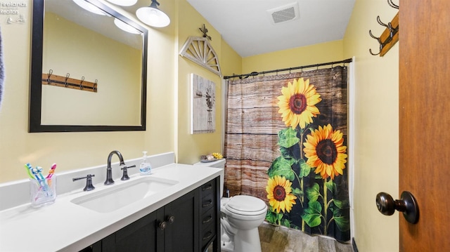 full bath with visible vents, toilet, a shower with curtain, wood finished floors, and vanity