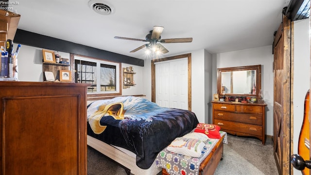 carpeted bedroom featuring visible vents, a closet, and a ceiling fan