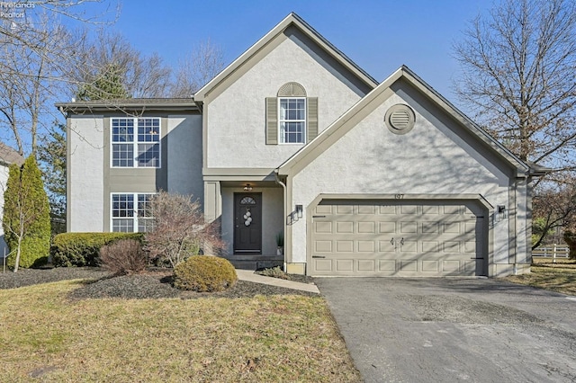 traditional home featuring stucco siding, a garage, and driveway