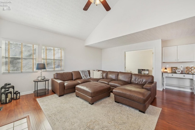 living room with baseboards, high vaulted ceiling, dark wood finished floors, ceiling fan, and a textured ceiling