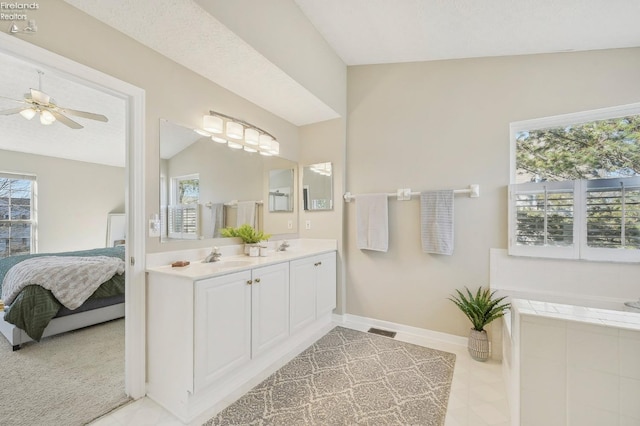 bathroom featuring baseboards, visible vents, ensuite bath, double vanity, and vaulted ceiling