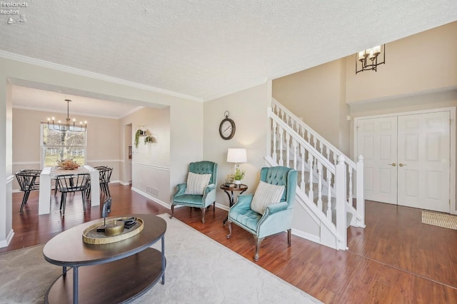 living room with stairs, wood finished floors, and a chandelier