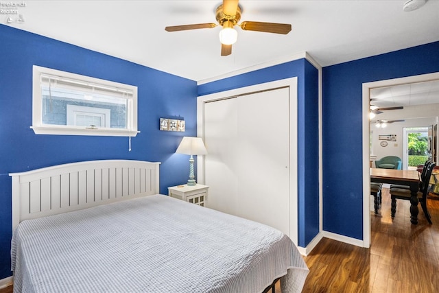 bedroom with baseboards, wood finished floors, a closet, and ceiling fan