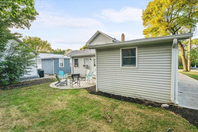 back of house featuring a lawn, cooling unit, a chimney, and a patio