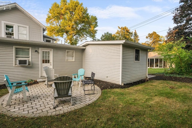 rear view of house featuring a lawn, cooling unit, and a patio