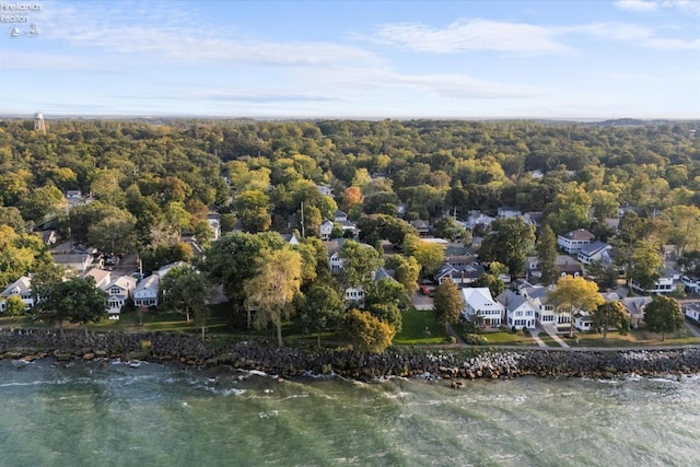 bird's eye view featuring a wooded view, a residential view, and a water view