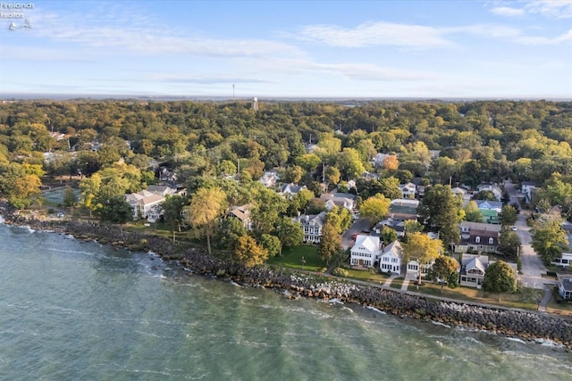 drone / aerial view featuring a wooded view and a water view