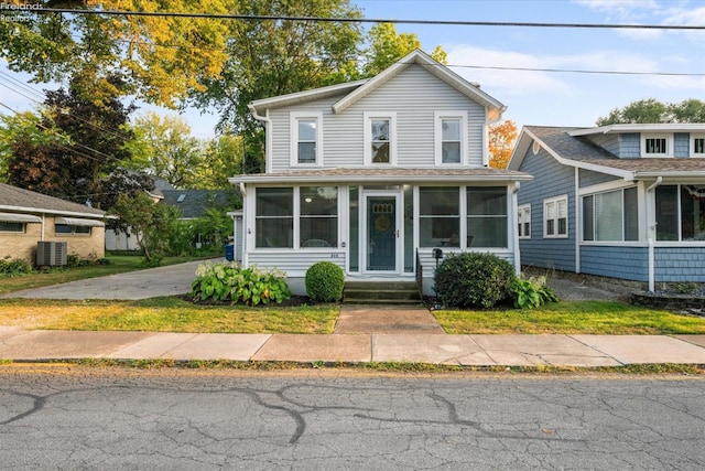 traditional home featuring central air condition unit and a sunroom