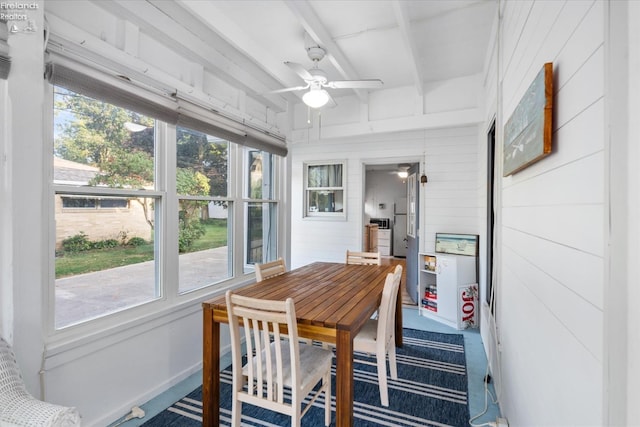 sunroom with beamed ceiling, a wealth of natural light, and ceiling fan