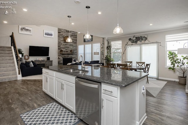 kitchen with stainless steel dishwasher, open floor plan, dark wood-style flooring, and a sink