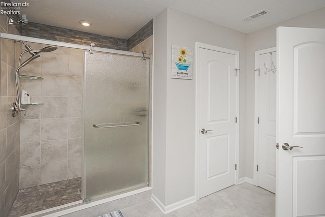 full bathroom featuring visible vents, baseboards, a textured ceiling, and a stall shower